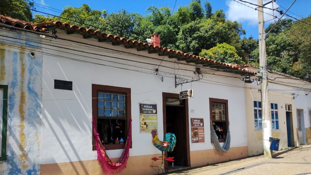 Fachada do Minas Parnaíba Café e Artes, com redes na janela e galo de ferro na porta, em Santana de Parnaíba
