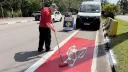 Funcionário da Prefeitura pinta de vermelho a ciclofaixa com rolo, ao lado de van e placa de obra, em Alphaville