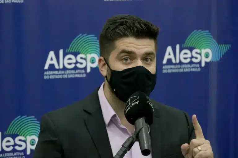 Deputado Danilo Joan, de máscara, fala ao microfone no plenário da Alesp, em foto de 2021, em São Paulo