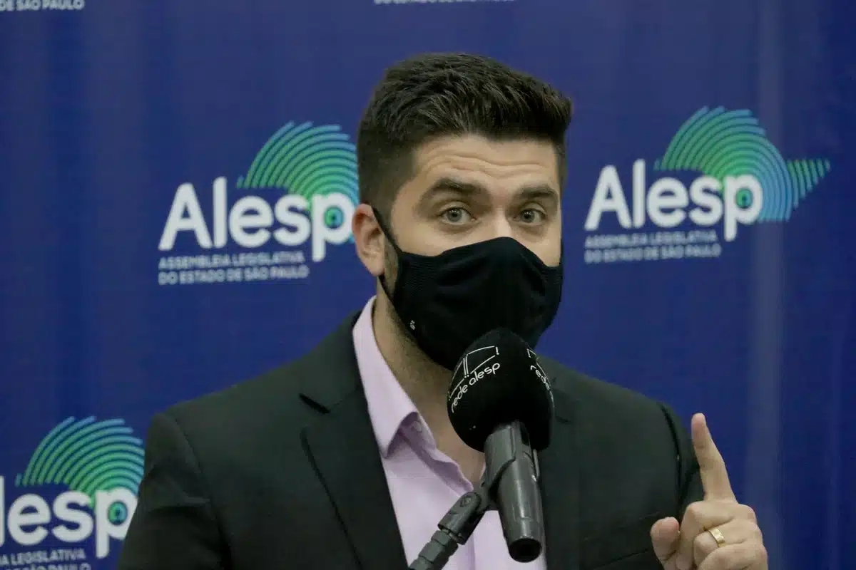 Deputado Danilo Joan, de máscara, fala ao microfone no plenário da Alesp, em foto de 2021, em São Paulo