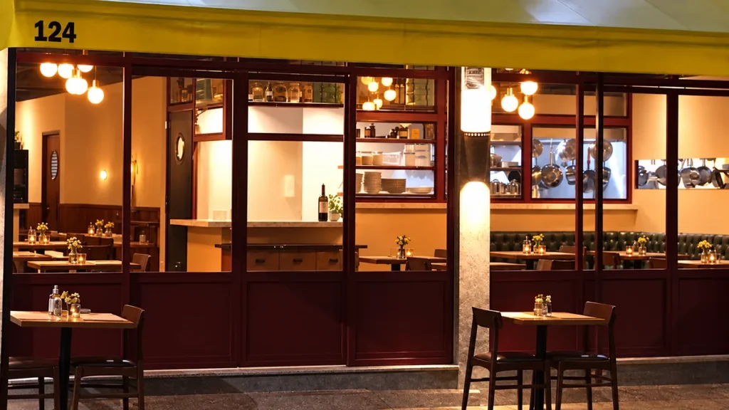 Fachada do Santa Bottega na Avenida Vênus, 124, em Alphaville, com toldo amarelo e vitrines de vidro