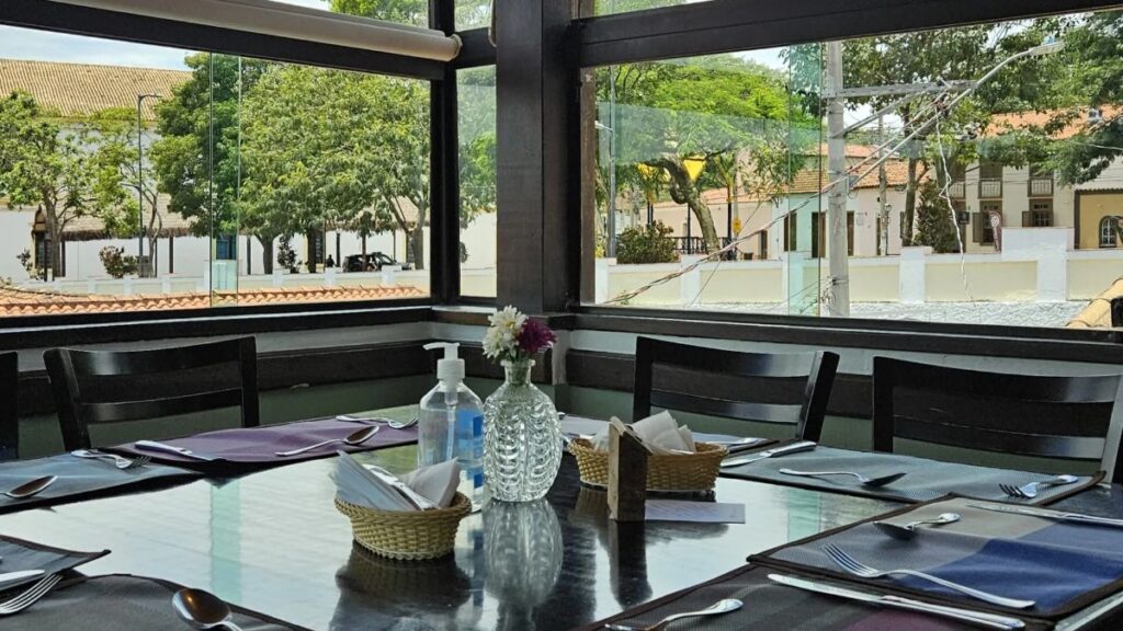 Mesa posta junto à janela do São Paulo Antigo Restaurante, com vista para as casas do Centro Histórico de Santana de Parnaíba